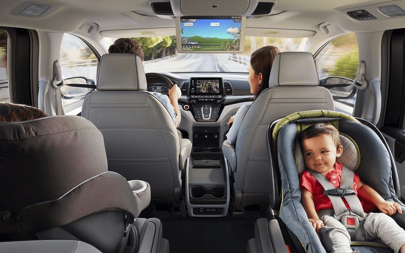 Honda Odyssey interior with children in carseats and multimedia display on