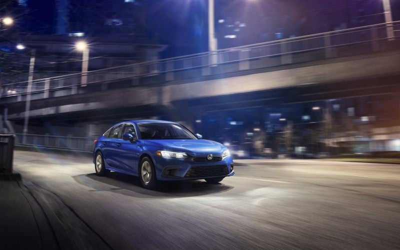 Honda civic driving through a downtown street at night