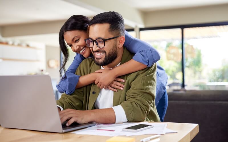 Happy couple shopping online with their laptop